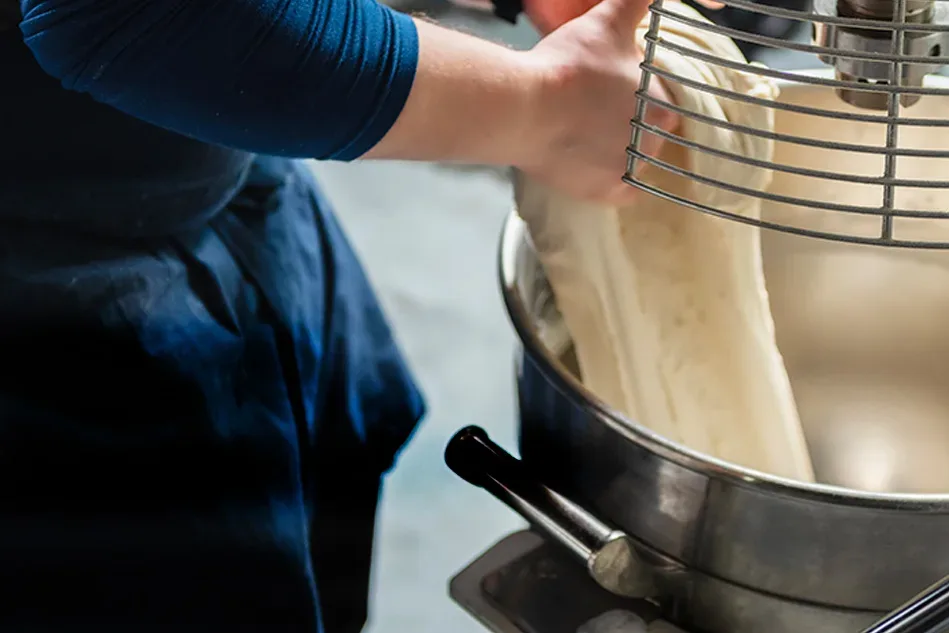 Institutional bakery using commercial mixers and dough-processing systems supplied by Erika Baking Equipment for large-scale foodservice production.
