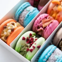 Colorful pink blue yellow green macaron. Sweet macaroons macarons. Macaroons in box. French macaroon cake. Sweet macarons or macaroons, flavored cookies are in the paper box on white background.