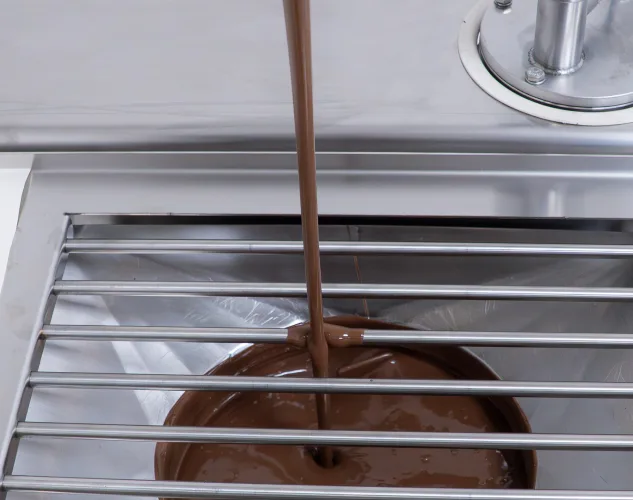 Bilait Adam K6 chocolate tempering machine dispensing tempered chocolate from outlet spout